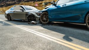 Head-on collision between blue and black cars with front-end damage.